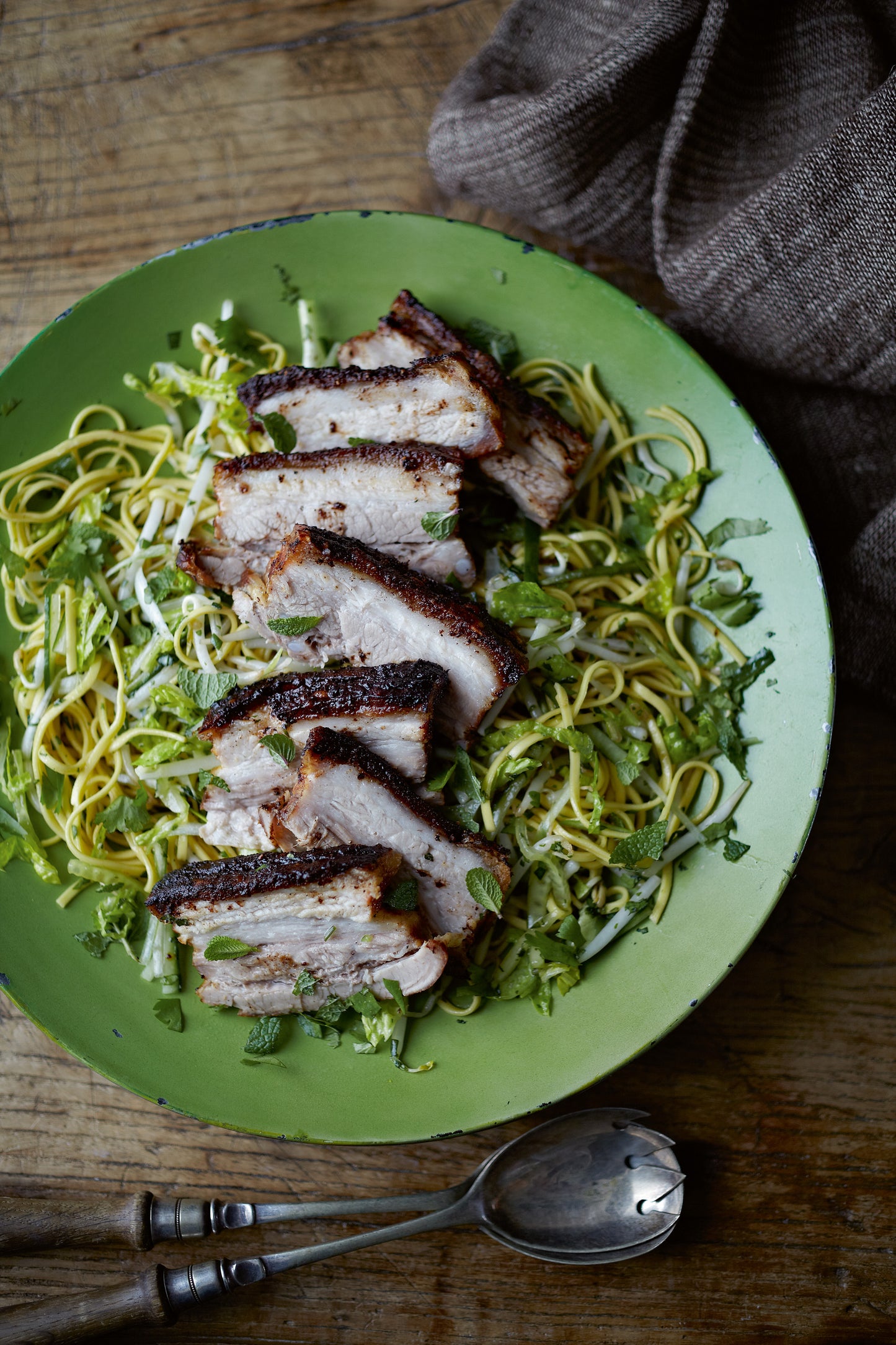Asia on a Plate by Event features sliced grilled pork atop noodles, fresh Thai herbs, and greens—beautifully served to bring you the authentic taste of Southeast Asian cuisine.