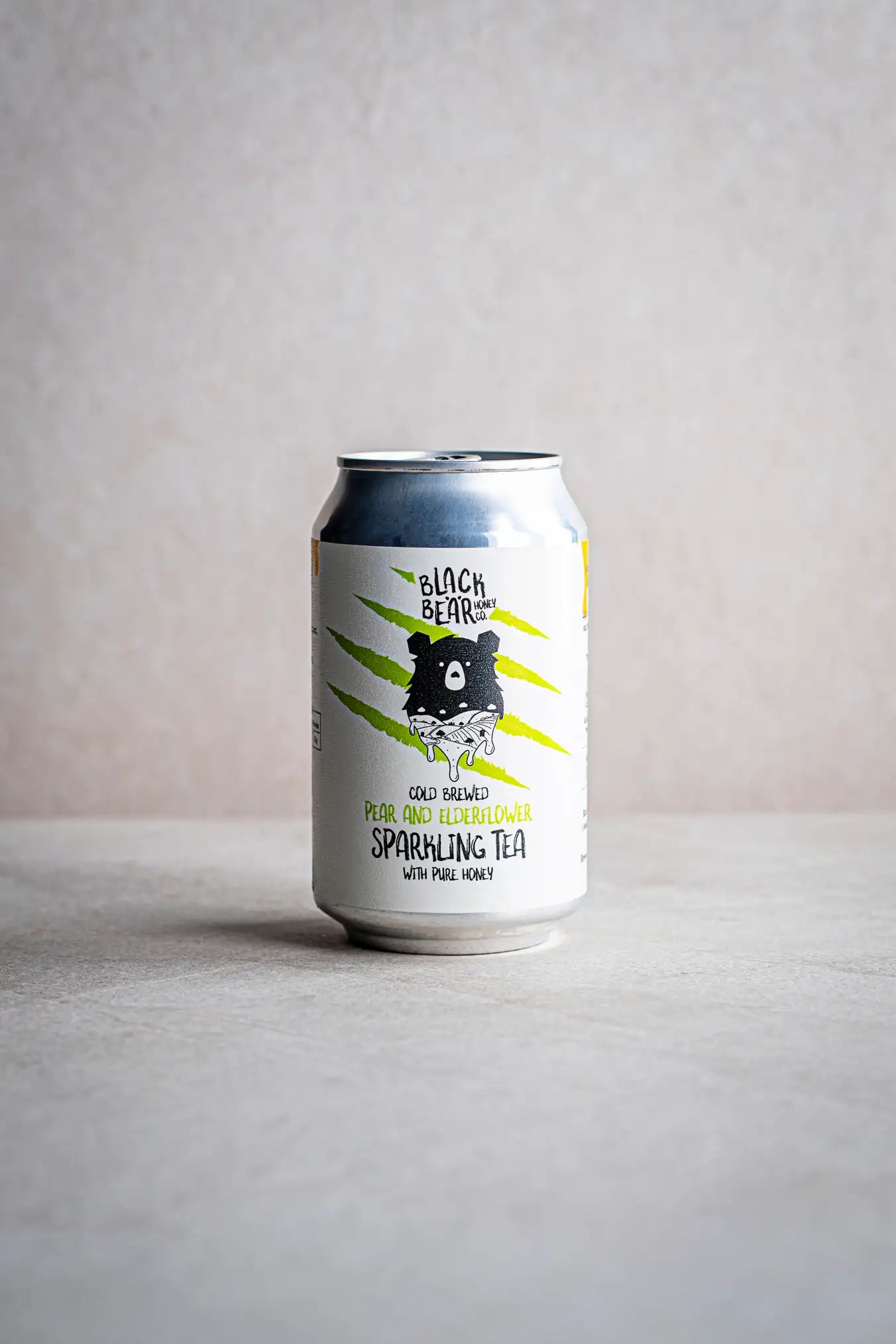 A can of Honesty Cold Brewed Sparkling Tea with Pure Honey, featuring green tea, pear, elderflower flavors, and a bear illustration on a light background.