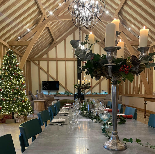 A festive dining room with a long table, candelabra, Christmas tree, and cozy seating—perfect for gathering tips from the Event Stress Free Christmas and hosting a joyful holiday celebration.