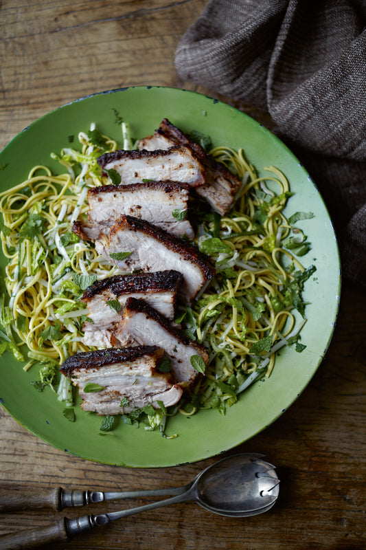 Asia on a Plate by Event features sliced grilled pork atop noodles, fresh Thai herbs, and greens—beautifully served to bring you the authentic taste of Southeast Asian cuisine.