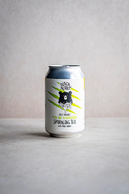 A can of Honesty Cold Brewed Sparkling Tea with Pure Honey, featuring green tea, pear, elderflower flavors, and a bear illustration on a light background.