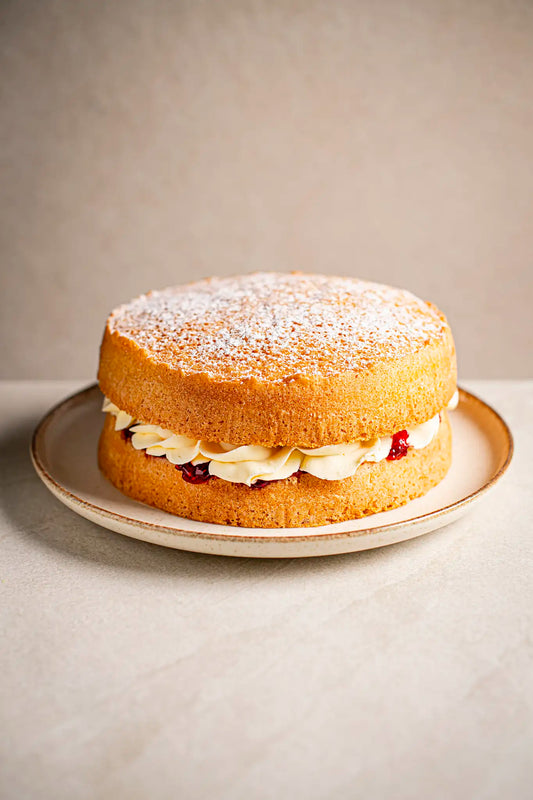Honesty Victoria Sponge: a classic handmade cake filled with cream and jam, topped with powdered sugar.