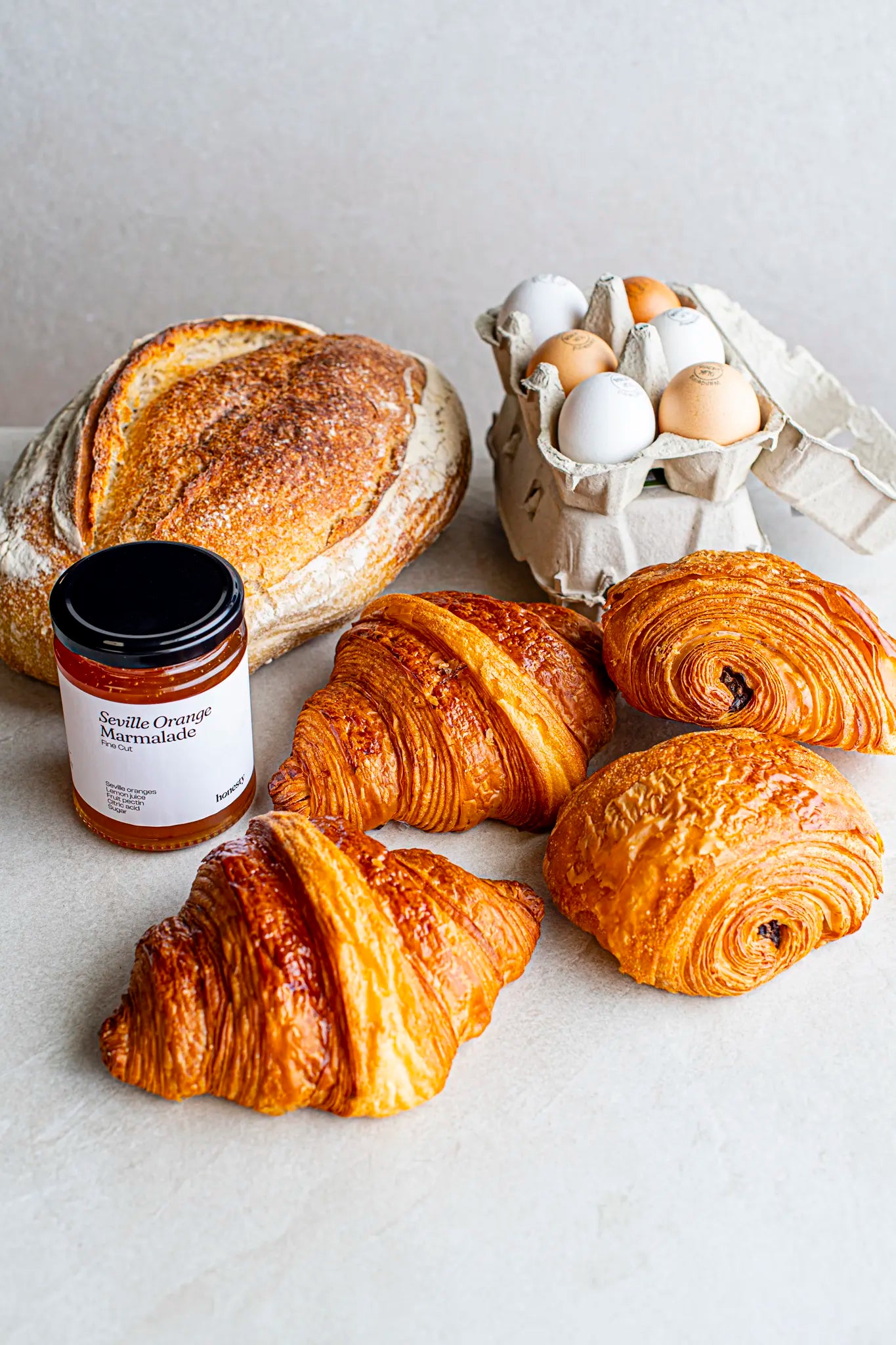 The Honesty "Weekender" bundle—your weekend escape essentials—includes rustic sourdough, pasture-raised eggs, Seville orange marmalade, croissants, and pain au chocolat.